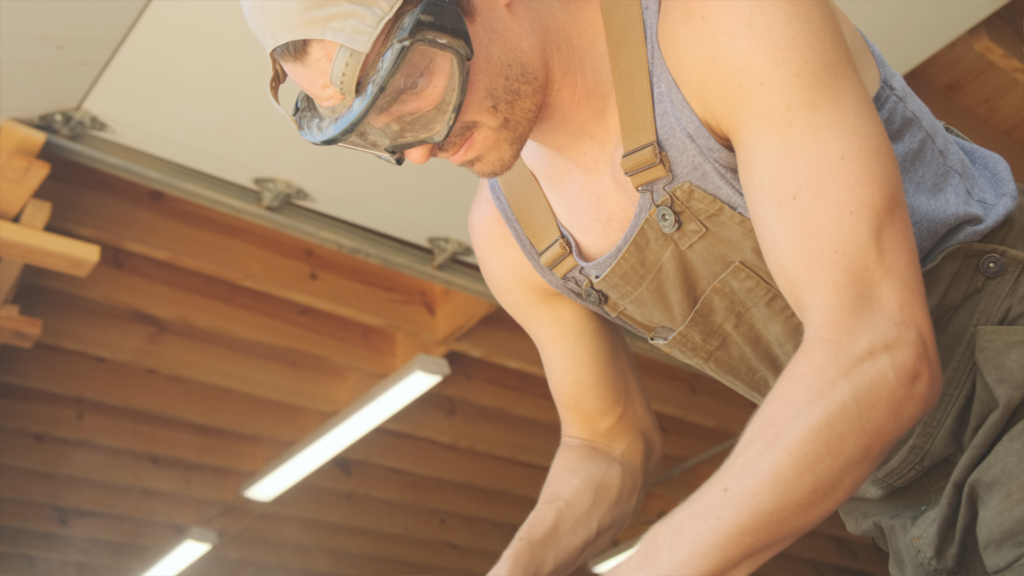 man with goggles sanding